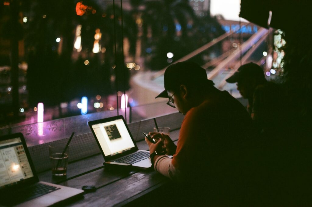 Person sitting at a laptop at night, putting in long work hours
